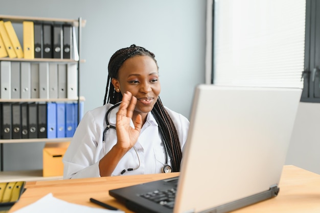 Médica africana fala com o paciente faz videochamada de webcam online de telemedicina Mulher terapeuta videoconferência no computador no bate-papo virtual do laptop de telemedicina remoto Conceito de telessaúde