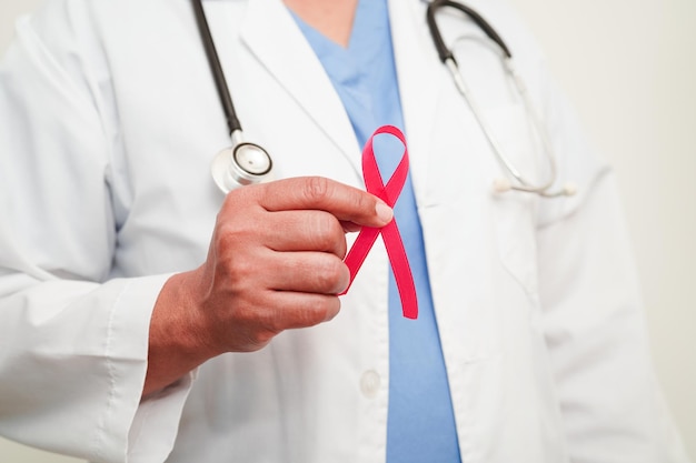 Médica asiática com fita rosa Dia Mundial do Câncer de Mama em outubro