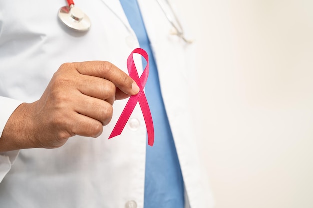 Médica asiática de câncer de mama com símbolo de fita rosa do Dia Mundial do Câncer de Mama