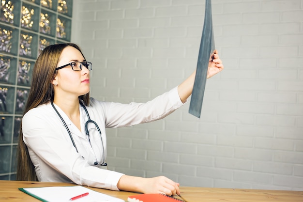 Médica atraente olhando os resultados dos raios-x