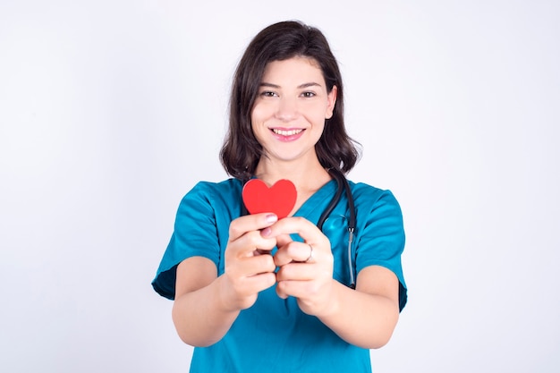 Médica com coração vermelho nas mãos