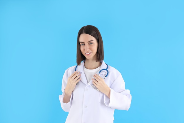 Médica com estetoscópio sobre fundo azul