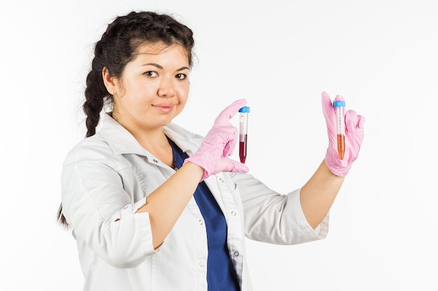 Médica com um estetoscópio segurando uma garrafa médica em um fundo branco