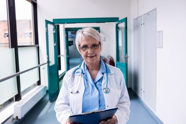 Médica confiante com pé de transferência no corredor do hospital