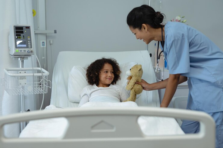 Foto médica dando un oso de peluche a un niño paciente en la sala