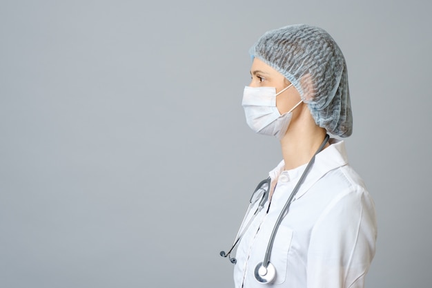 Médica de retrato em máscara médica protetora e boné