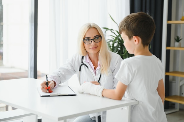 Médica e menino com um braço quebrado