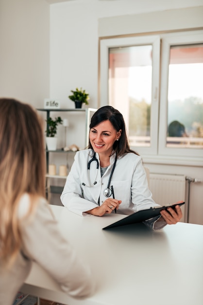 Foto médica e paciente do sexo feminino falando sobre os resultados do teste.