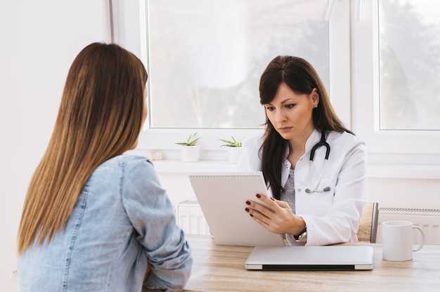 Médica e paciente. Lendo os resultados.