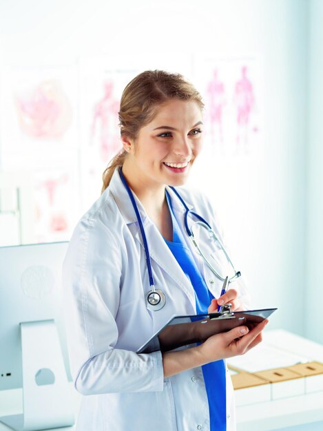 Médica em pé com a pasta no hospital