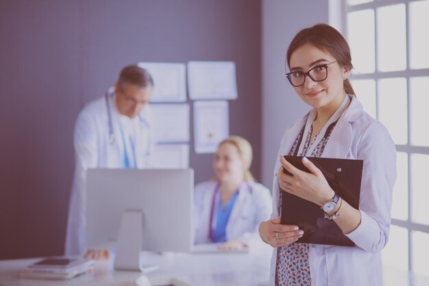 Médica em pé com estetoscópio no hospital