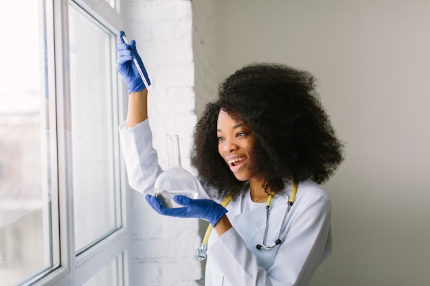 Médica em um jaleco branco com um estetoscópio.