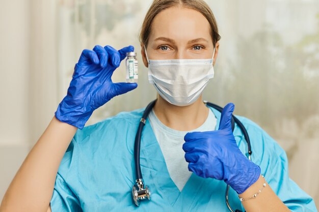 Médica, enfermeira, cientista com estetoscópio, usando luvas azuis segurando coronavírus, doença da vacina covid-19, preparando-se para o conceito de vacinação, medicamento e droga.