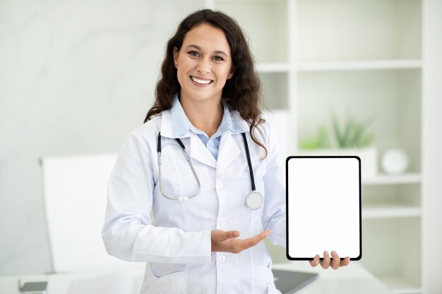 Foto médica europeia alegre segurando um tablet digital