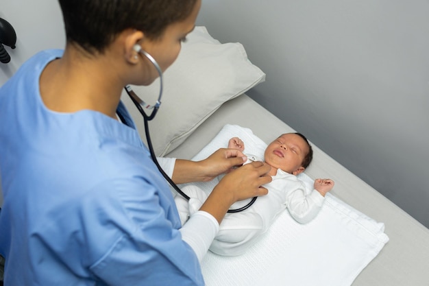 Foto médica examinando a un bebé con un estetoscopio en la sala de exámenes médicos