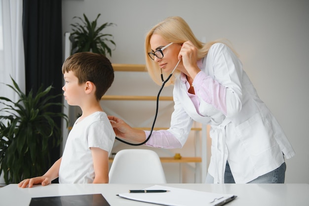 Médica examinando menino por estetoscópio
