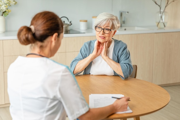 Médica examinando uma mulher mais velha no consultório do médico ou em casa, uma mulher idosa, uma doente e