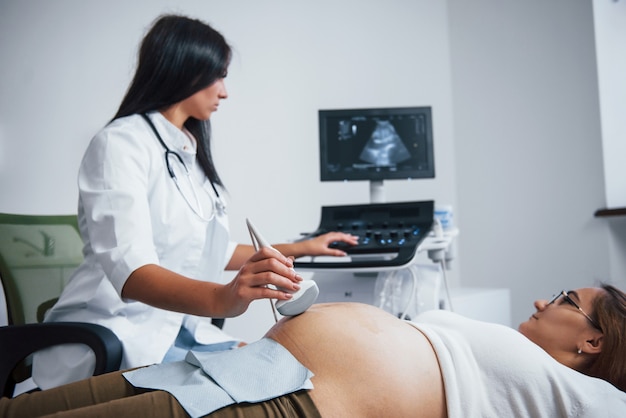 Médica faz ultrassom para uma mulher grávida no hospital.