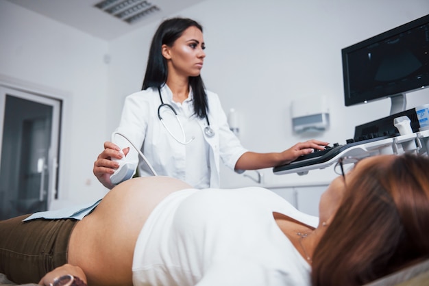 Médica faz ultrassom para uma mulher grávida no hospital.