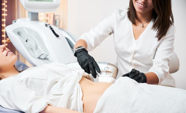 Foto médica haciendo una ecografía del abdomen para un paciente con guantes negros de goma concepto de equipos modernos en la clínica para mejorar la salud