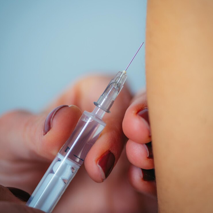 Foto médica injetando seringa no ombro de uma mulher no hospital