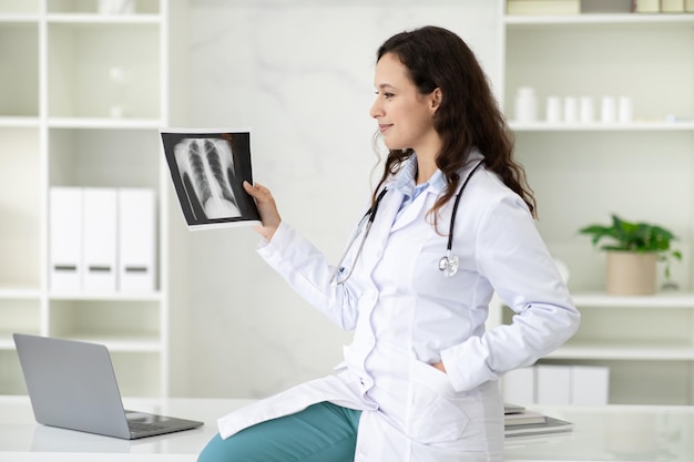 Foto médica jovem feliz olhando para imagem de radiografia de raio x