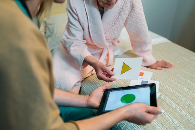 Médica mostrando jogo de forma geométrica para paciente idosa com demência