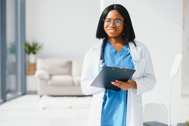 Médica negra bem-sucedida sorrindo no escritório