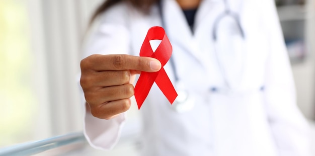 Médica negra segurando uma fita vermelha