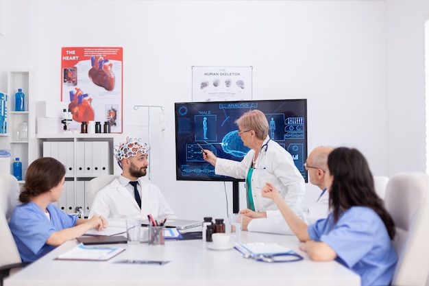 Médica neurologista sênior apresentando experiência médica no cérebro durante conferência de saúde