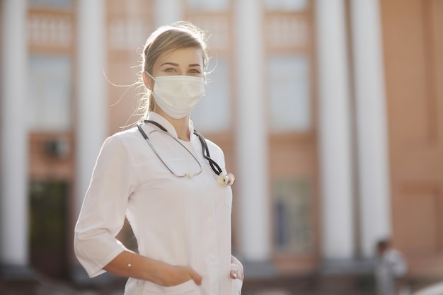 Médica ou enfermeira usando uma máscara protetora com um estetoscópio no pescoço