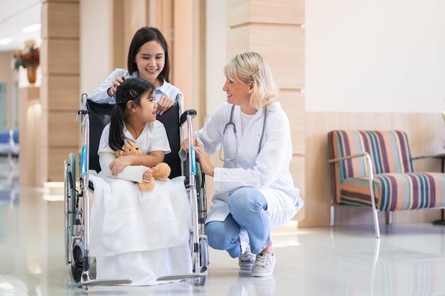 Médica pediatra e paciente infantil em cadeira de rodas com a mãe