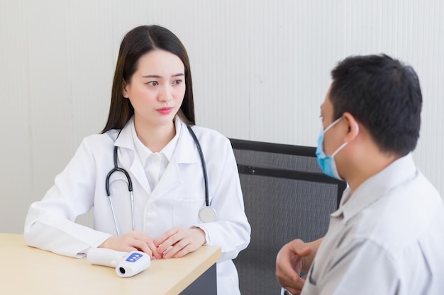 Médica profissional asiática falando com um paciente homem sobre sua dor de estômago sintoma