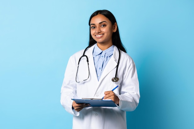 Foto médica profissional indiana com estetoscópio e estúdio de gráficos médicos