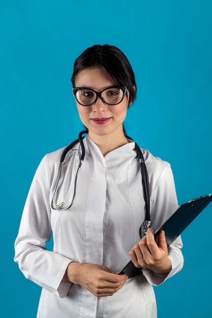 Médica segurando a prancheta na mão olhando para a câmera e sorrindo