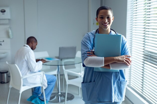 Foto médica segurando arquivo e sorrindo no hospital