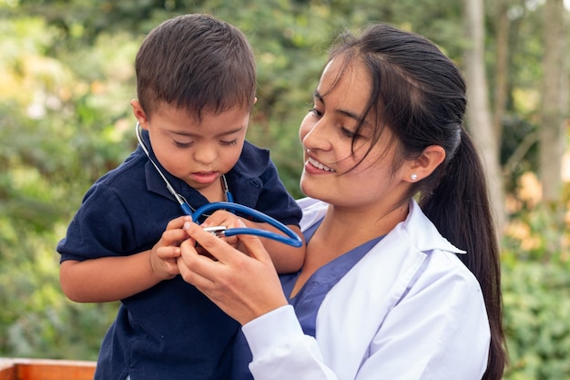 Médica segurando nos braços uma criança com síndrome de Down a quem emprestou seu estetoscópio