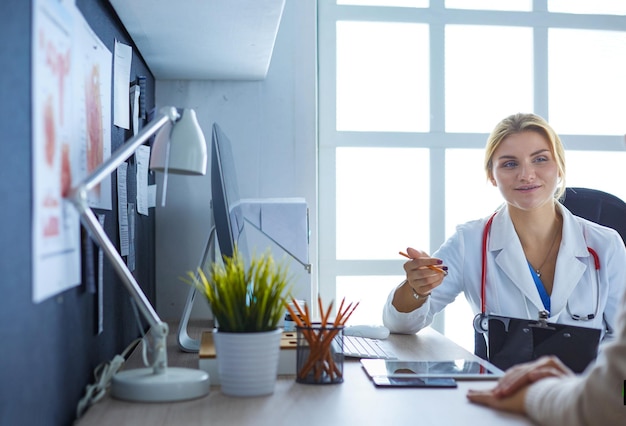 Médica segurando o formulário de inscrição enquanto consulta o paciente