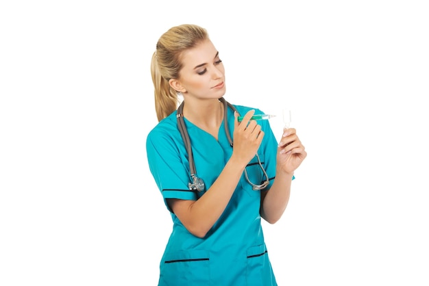 Médica segurando seringa e garrafa contra fundo branco