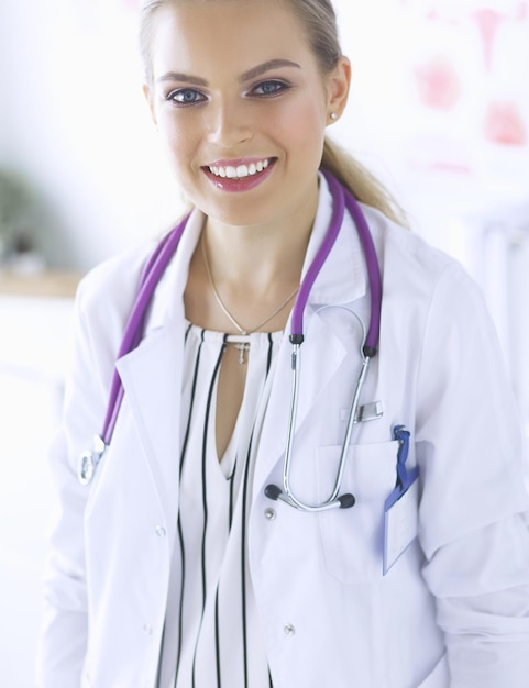 Médica sorridente com um estetoscópio médico em uniforme de pé