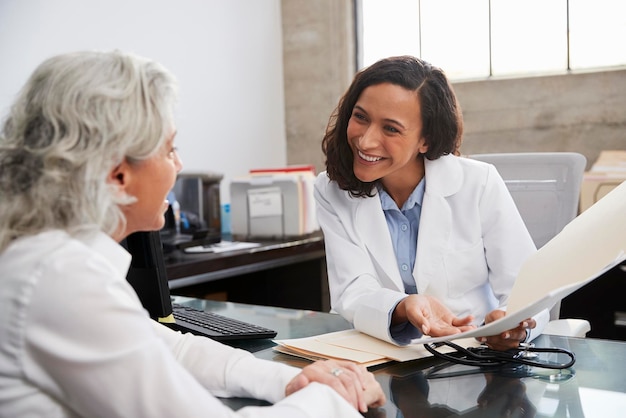 Médica sorridente em consulta com paciente sênior