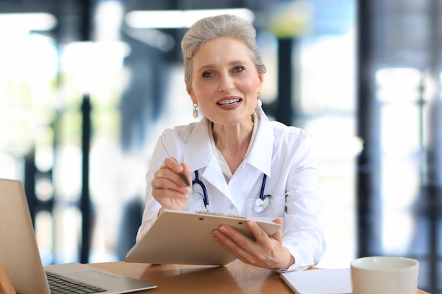 Médica terapeuta idosa usando videochamada com fone de ouvido conversando com uma câmera da web consultando paciente virtual on-line por bate-papo por videoconferência