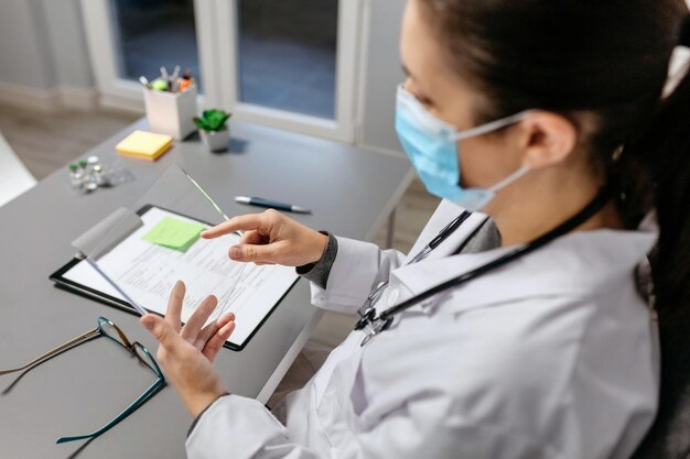 Médica trabajando con una tableta transparente