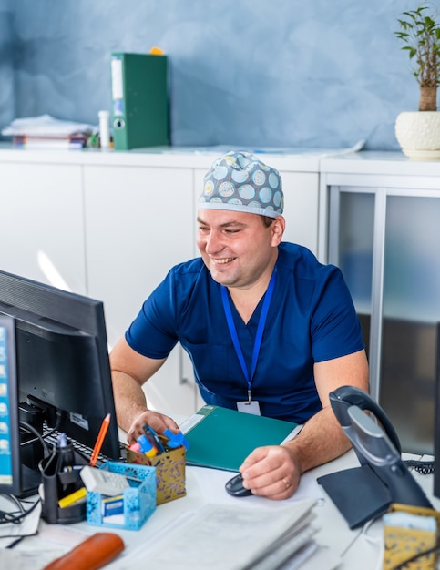 Médica trabalhando em perícia médica enquanto está sentado na mesa na frente do computador.