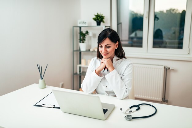 Médica, trabalhando na mesa do escritório.