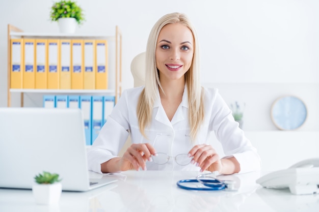 médica trabalhando no laptop em seu escritório