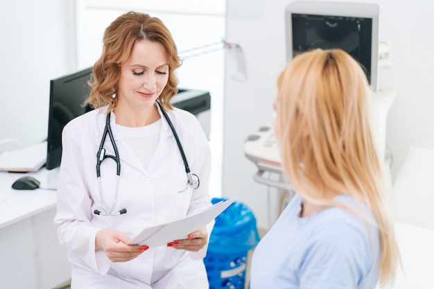 Foto médica transmite à jovem grávida de cabelos loiros os resultados e relatórios