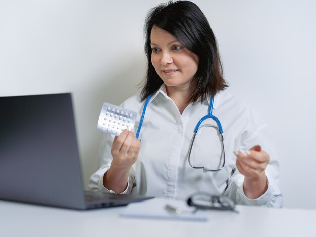 Médica usando computador laptop com videochamada remota conversando com paciente prescrever medicamento