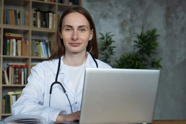 Médica usando seu laptop em um consultório médico