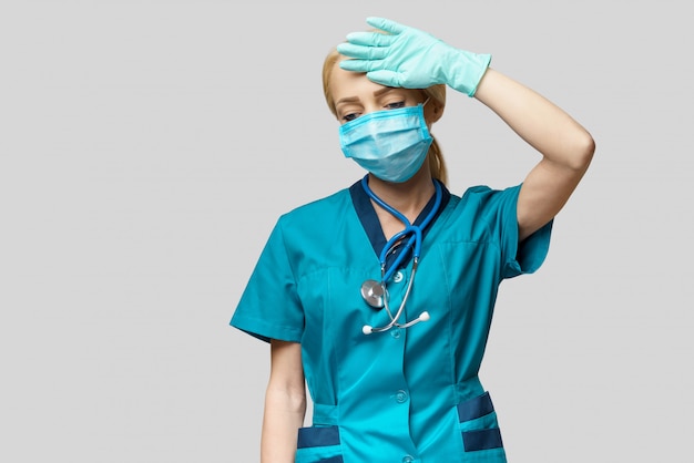 Médica vestindo máscara protetora e luvas de látex dor de cabeça e estresse